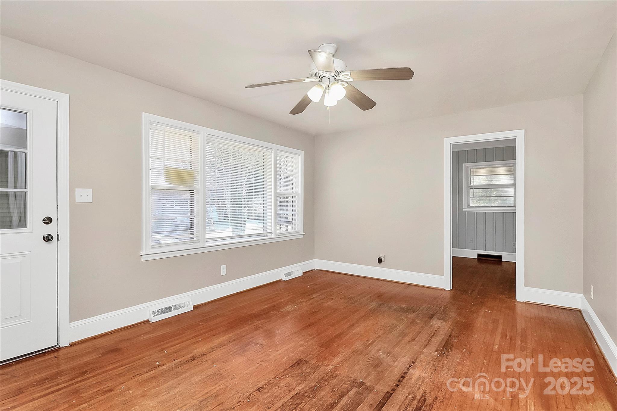 4919 Raymond Place Charlotte, NC 28205 - Photo 5 of 31 a view of an empty room with wooden floor and a window