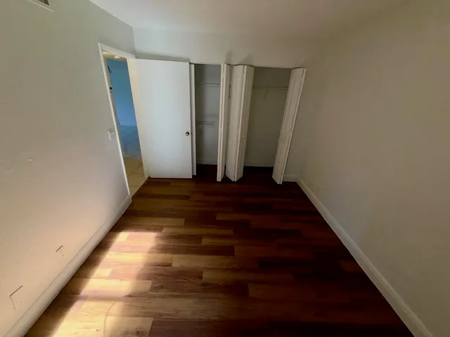a view of room with wooden floor and windows