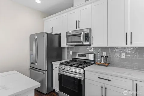a kitchen with stainless steel appliances a refrigerator stove and microwave