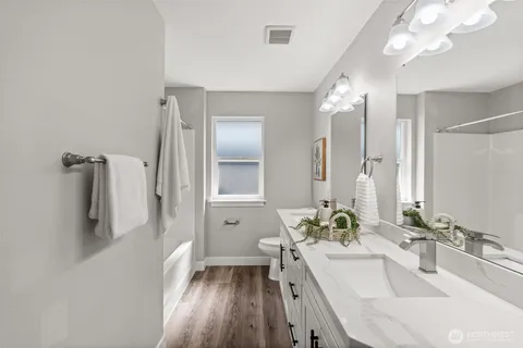 a bathroom with a bathtub sink and mirror