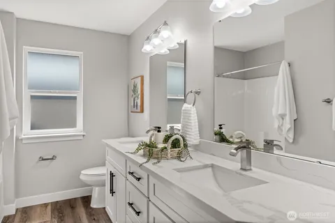 a bathroom with a double vanity sink a toilet and a mirror