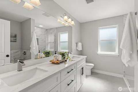 a bathroom with a double vanity sink and a mirror