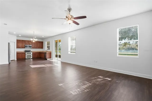 a view of a livingroom with furniture wooden floor and a kitchen