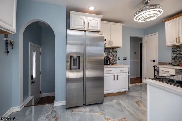 a kitchen with stainless steel appliances granite countertop a refrigerator a stove and a sink