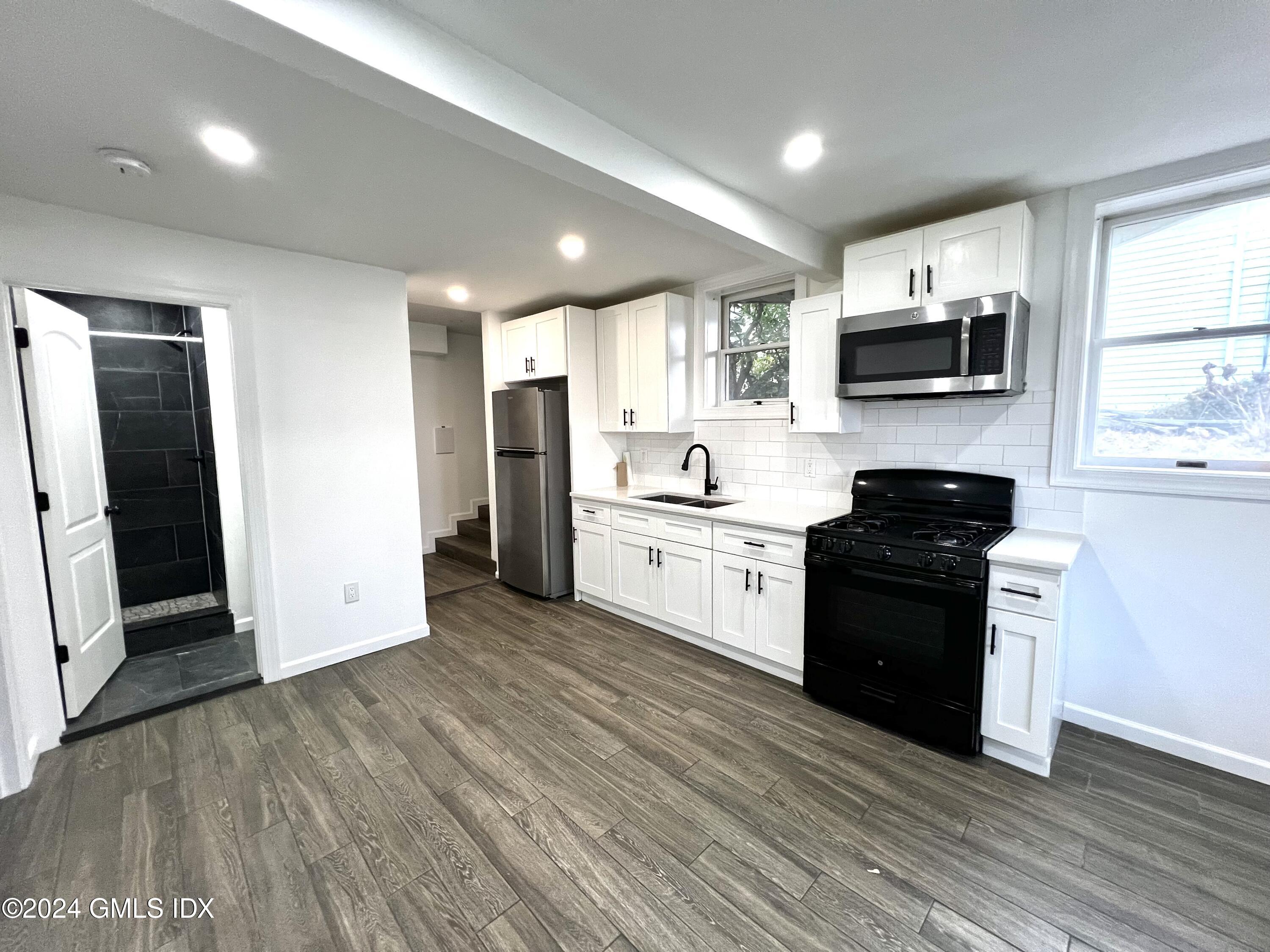 119 North Water Street, Unit 1 Greenwich, CT 06830 - Photo 3 of 11 a kitchen with a sink a microwave and cabinets