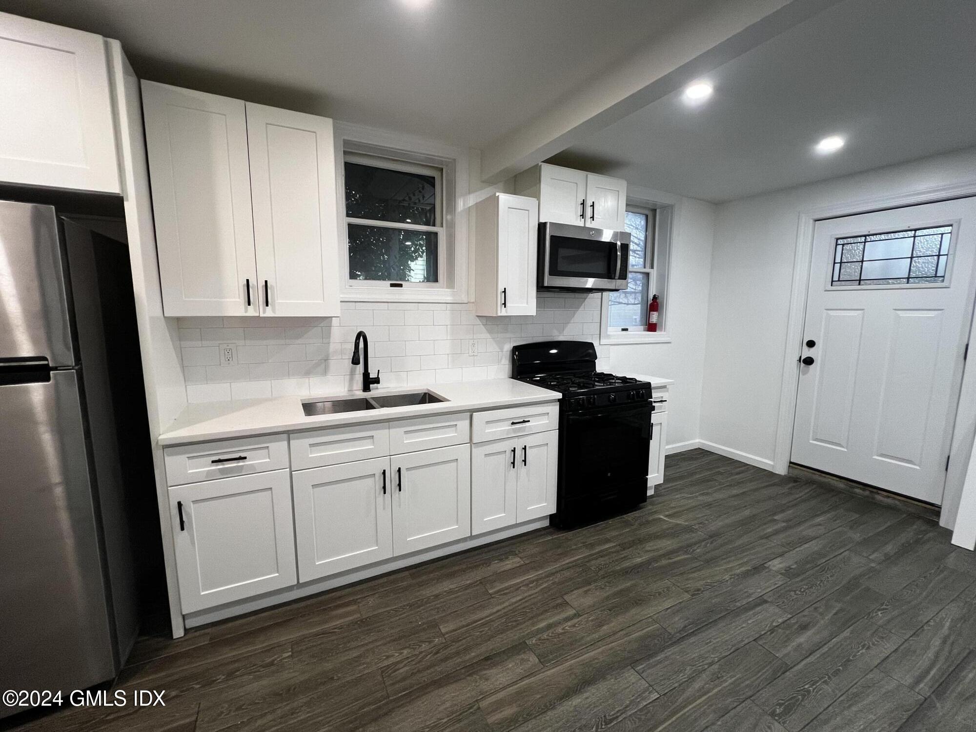 119 North Water Street, Unit 1 Greenwich, CT 06830 - Photo 5 of 11 a kitchen with stainless steel appliances a refrigerator sink and microwave