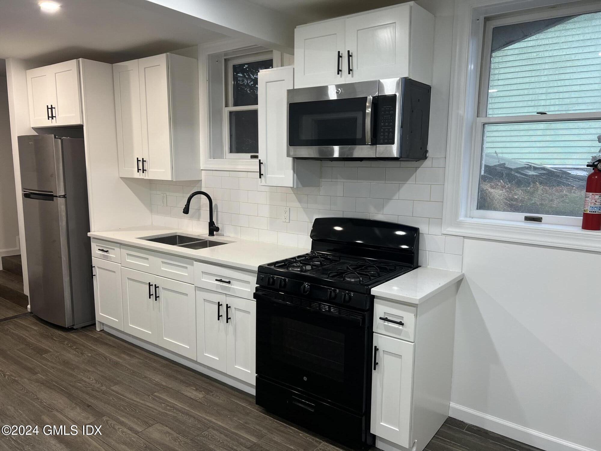 119 North Water Street, Unit 1 Greenwich, CT 06830 - Photo 6 of 11 a kitchen with a sink stove and microwave