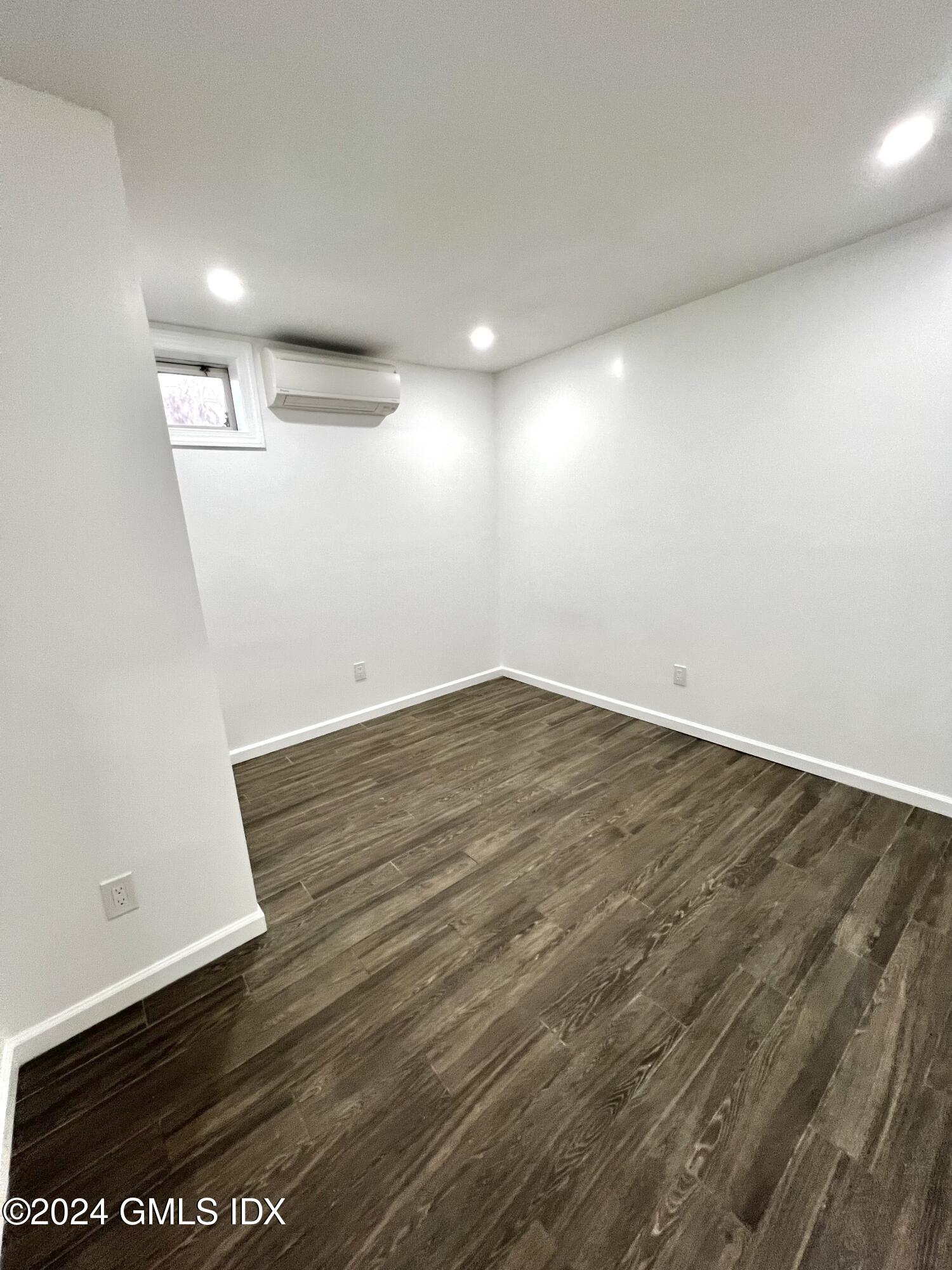 119 North Water Street, Unit 1 Greenwich, CT 06830 - Photo 9 of 11 an empty room with wooden floor and windows