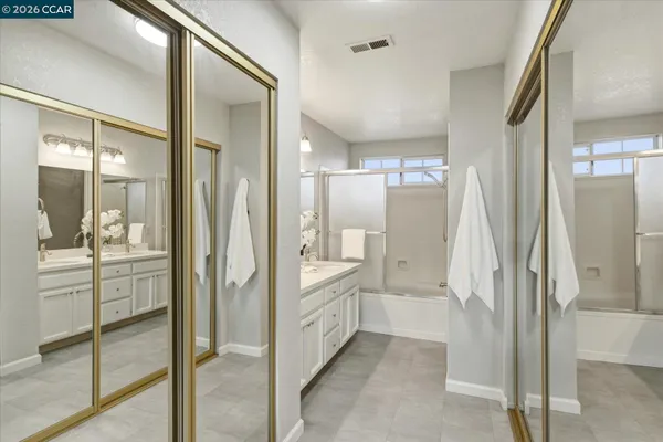 a bathroom with a glass door shower a sink and a mirror