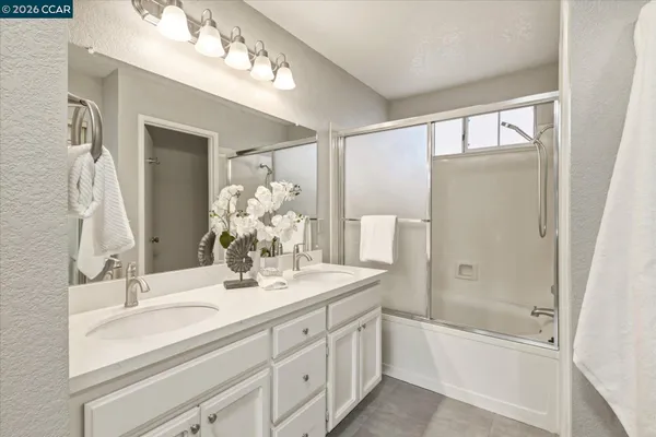 a bathroom with a bathtub shower sink and mirror