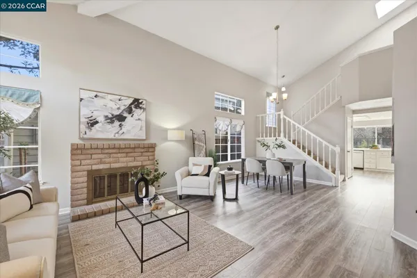 a living room with furniture a fireplace and a chandelier