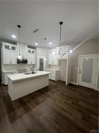a large room with kitchen view and a chandelier