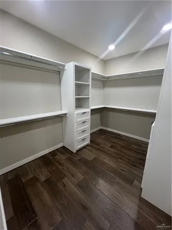 a room with walk in closet and wooden floor