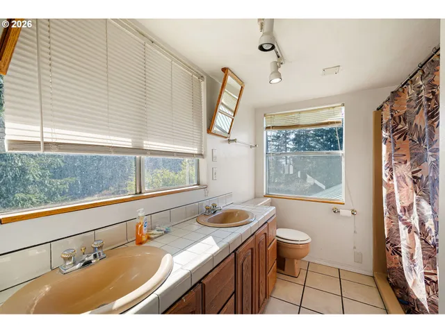 a bathroom with a granite countertop sink mirror vanity and a bathtub