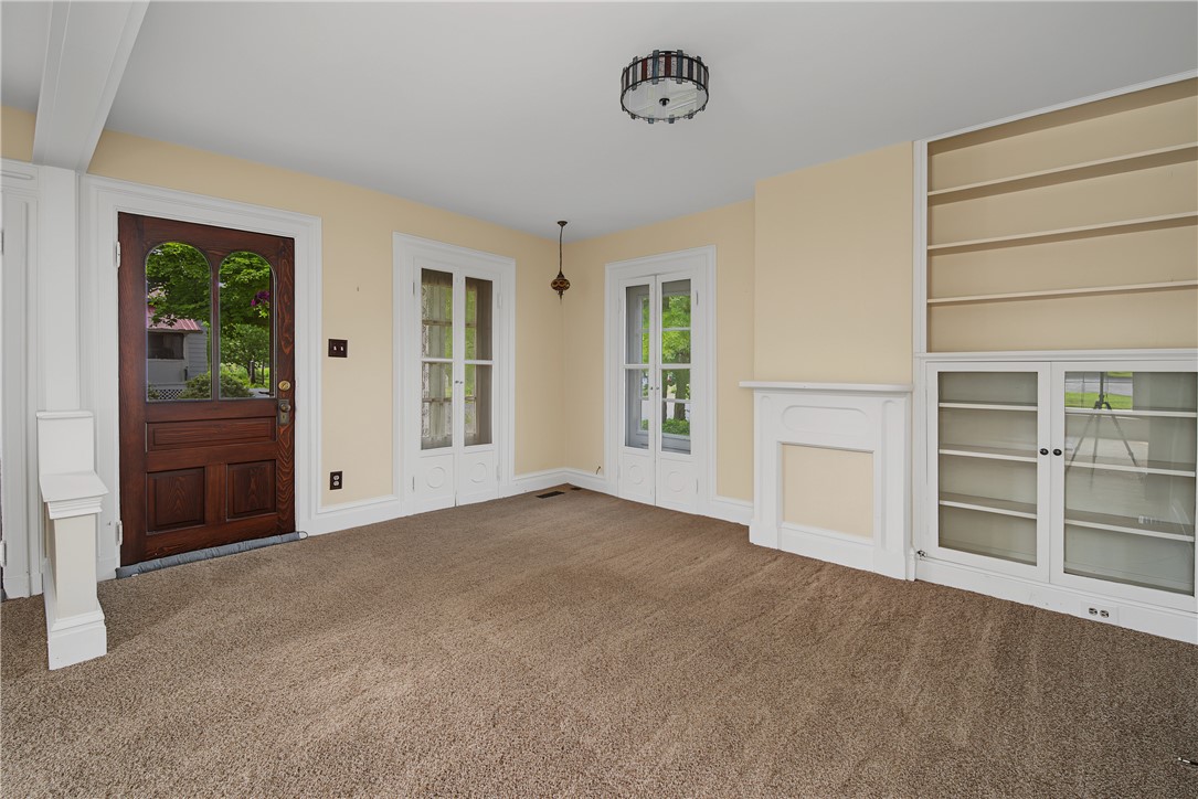 8707 Lytle Ferry Road Waynesville, OH 45068 - Photo 7 of 54 A warm and inviting living space with carpeted flooring and elegant built-in shelving.