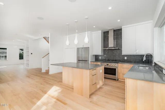 a large kitchen with stainless steel appliances kitchen island granite countertop a sink and a stove