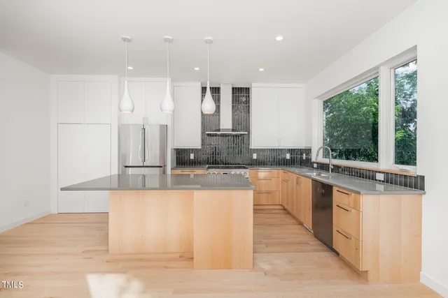 a large kitchen with kitchen island granite countertop a large window