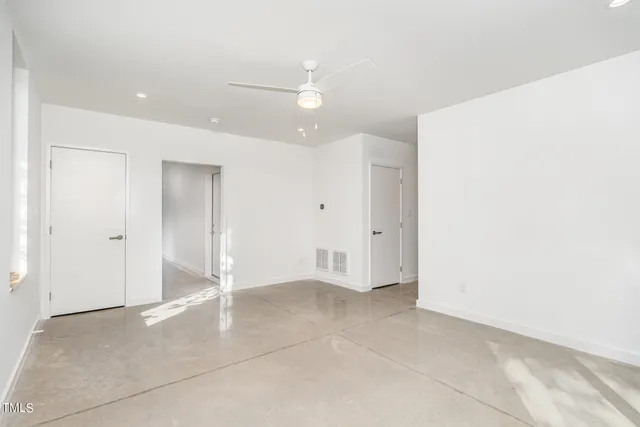 an empty room with a ceiling fan and bathroom