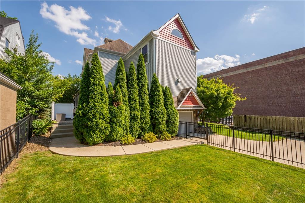 607 Broad Street Sewickley, PA 15143 - Photo 38 of 45 a view of a house with brick walls and flower plants next to a yard