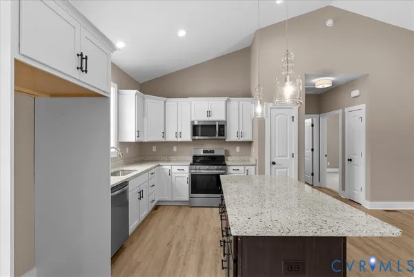 a large kitchen with stainless steel appliances granite countertop a stove and a sink