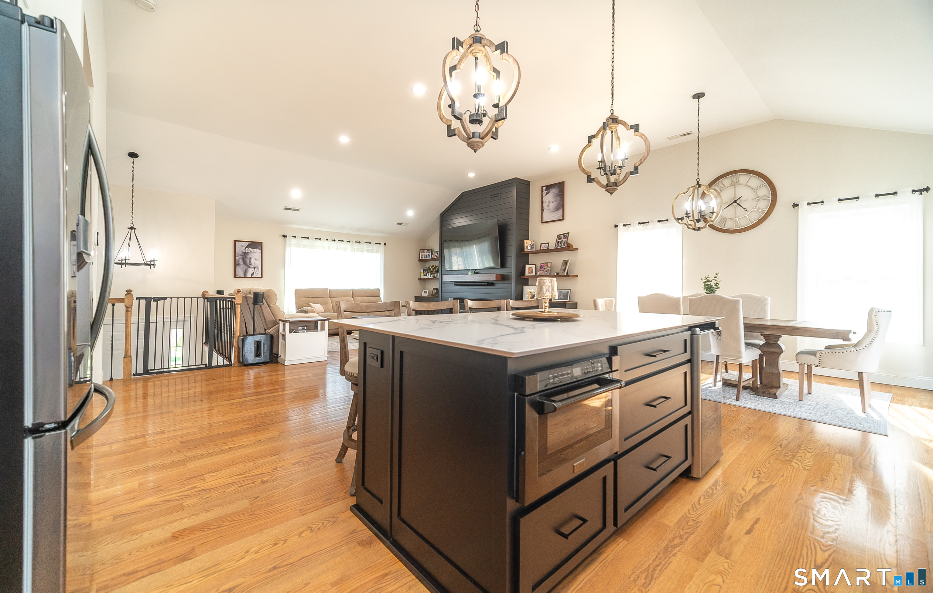 69 Cronin Street Bristol, CT 06010 - Photo 5 of 40 a kitchen with stainless steel appliances granite countertop a stove a sink dishwasher and a fireplace with wooden floor