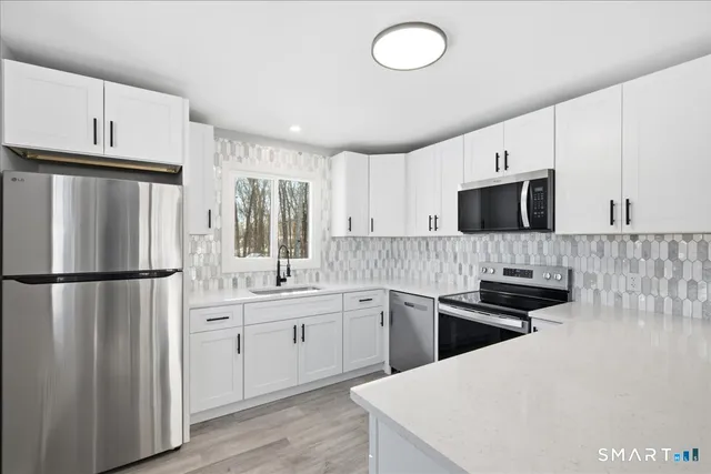 a kitchen with a sink a refrigerator a microwave and cabinets