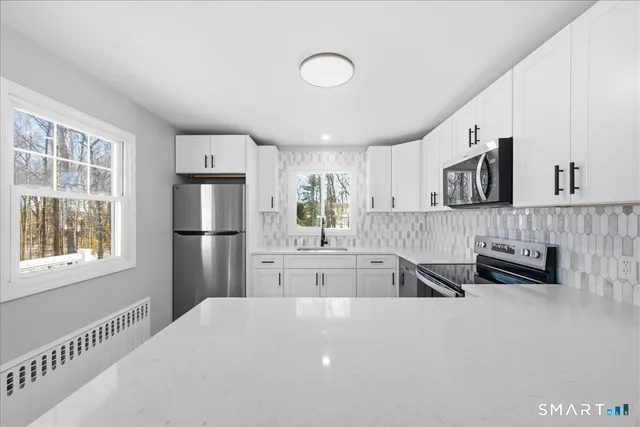 a kitchen with stainless steel appliances a refrigerator and a stove top oven