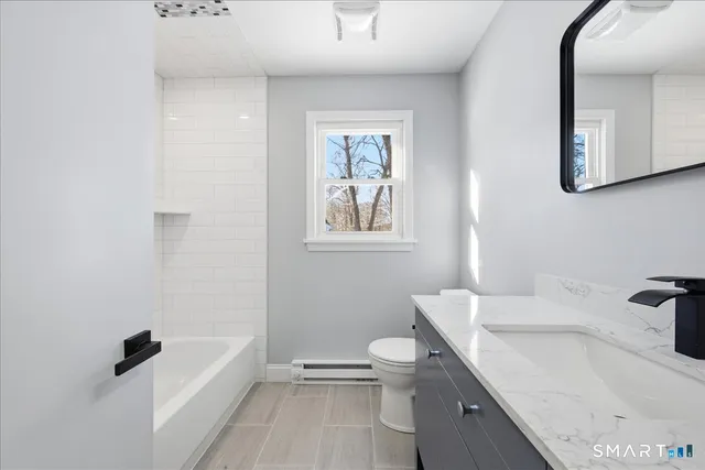 a bathroom with a granite countertop sink a toilet and shower