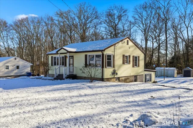 a front view of a house with a yard covered in snow