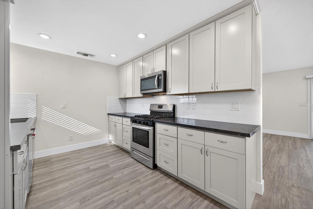 7517 Farmgate Way Citrus Heights, CA 95610 - Photo 16 of 35 a kitchen with granite countertop white cabinets and white appliances