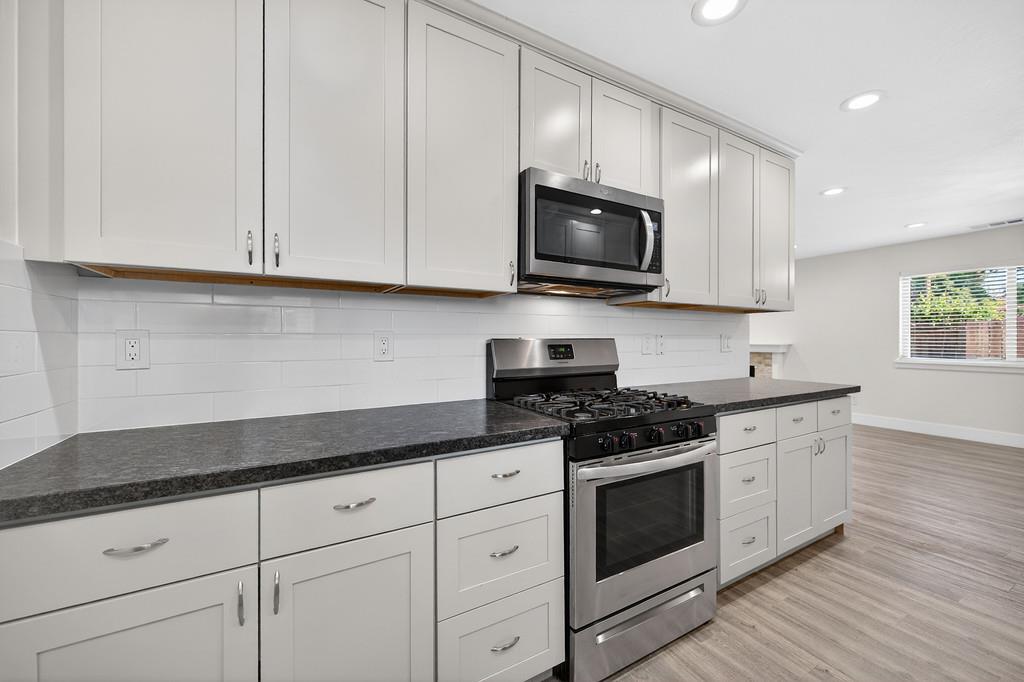 7517 Farmgate Way Citrus Heights, CA 95610 - Photo 17 of 35 a kitchen with white cabinets and black appliances