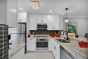 a kitchen with stainless steel appliances granite countertop a sink stove and refrigerator