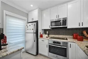 a kitchen with stainless steel appliances granite countertop a sink stove and microwave