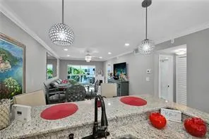 a room with kitchen island granite countertop furniture and a chandelier