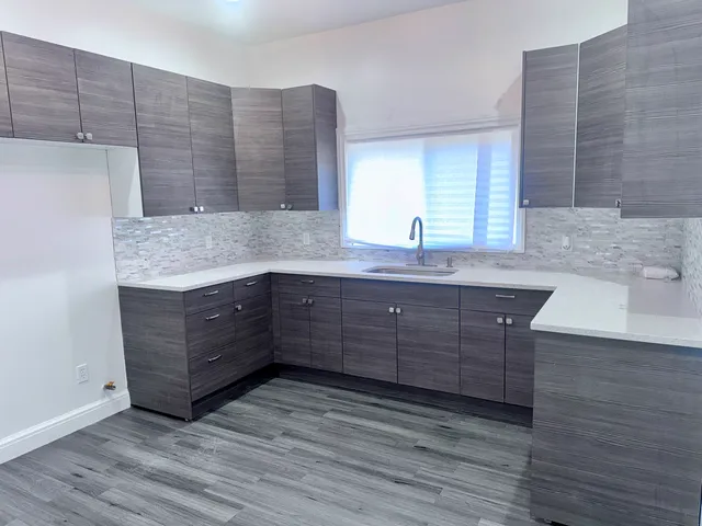 a kitchen with a wooden floor and cabinets