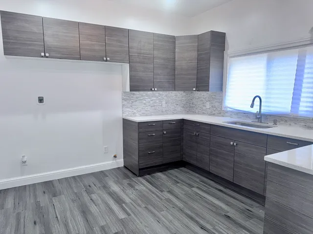 a kitchen with a sink and wooden floor
