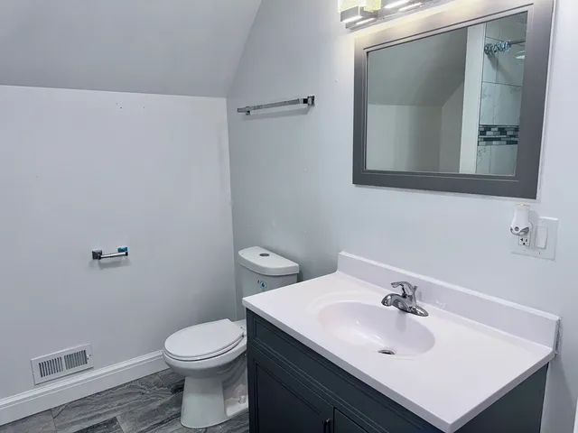 a bathroom with a sink toilet and mirror