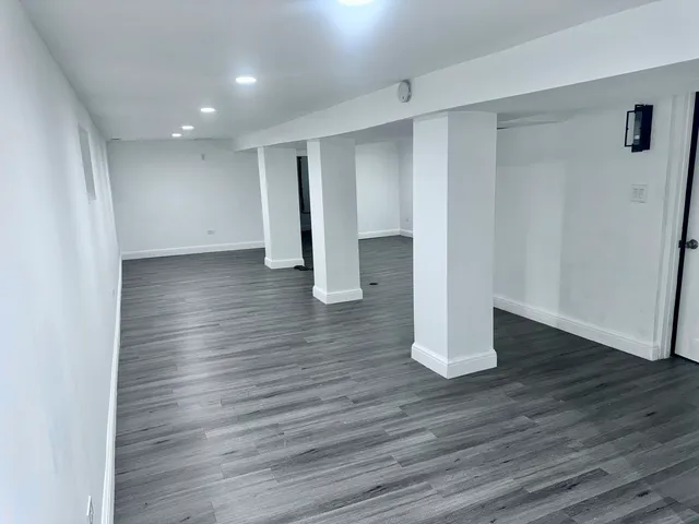 a view of an empty room with wooden floor and closet