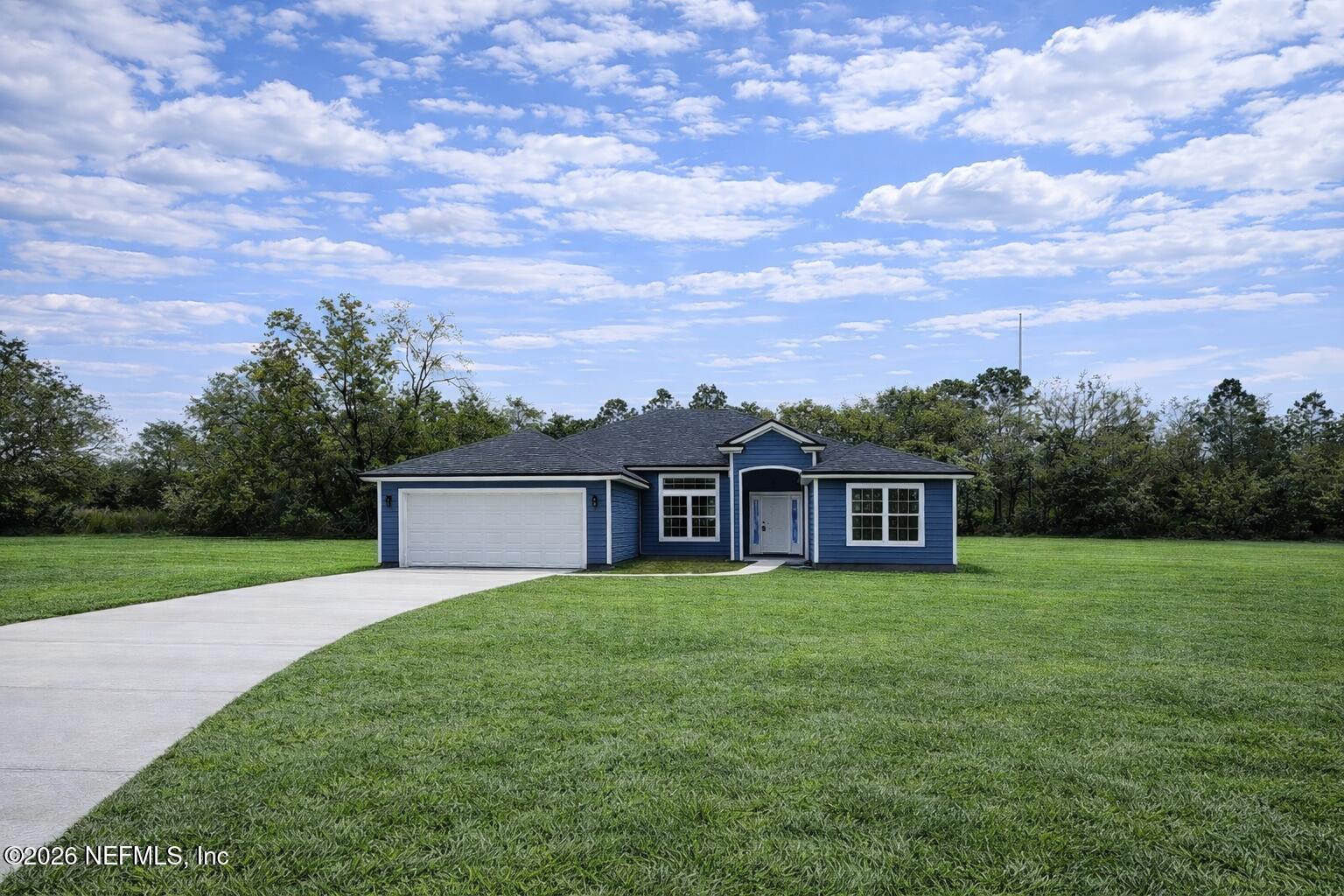 a view of a house with a big yard and a large tree