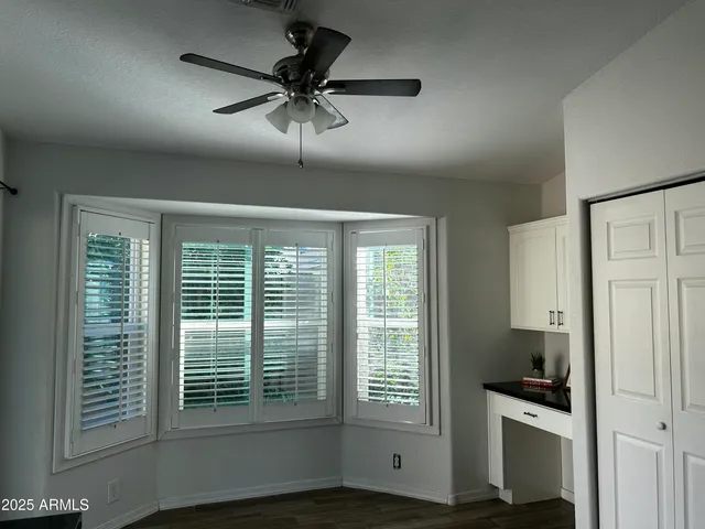 a view of a livingroom with a ceiling fan and window