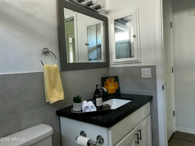 a bathroom with a granite countertop sink and a mirror