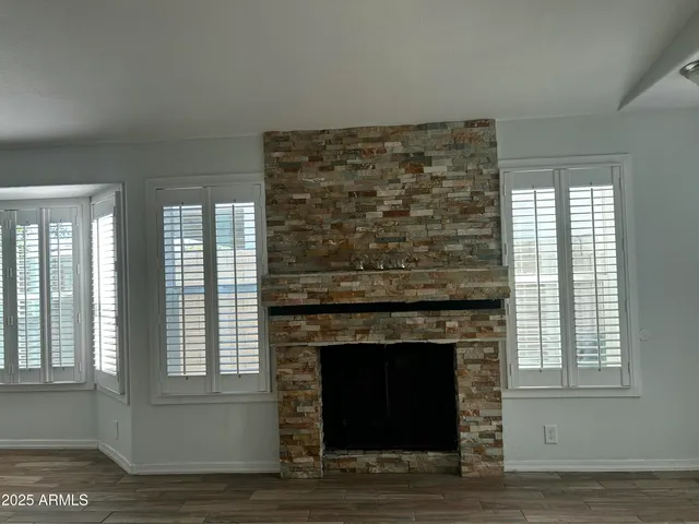 a living room with a fireplace and windows