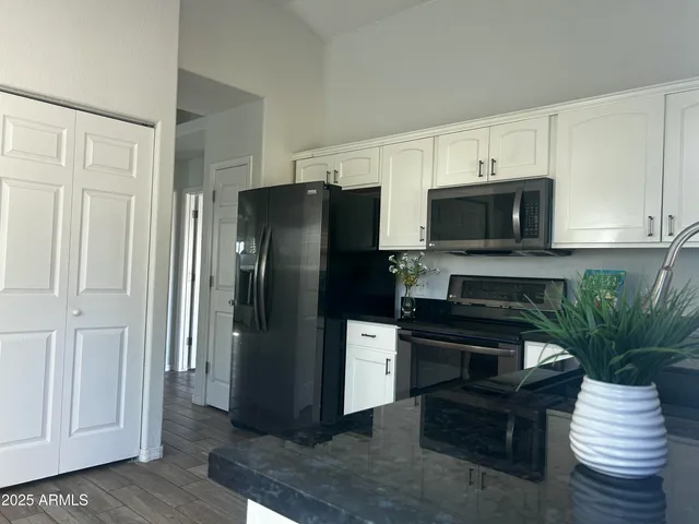 a kitchen with stainless steel appliances a refrigerator a stove a microwave and cabinets