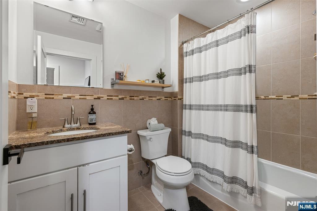 7 Oakdene Terrace, Unit 7 Edgewater, NJ 07020 - Photo 23 of 30 a bathroom with a granite countertop sink a toilet and shower