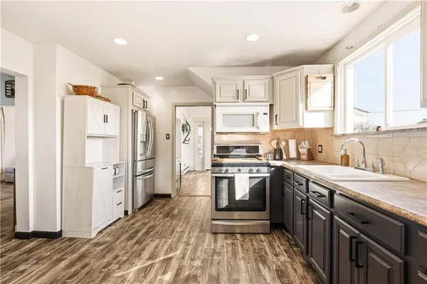 a kitchen with stainless steel appliances a refrigerator sink and microwave