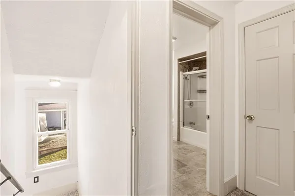 a view of a hallway with wooden floor and closet area