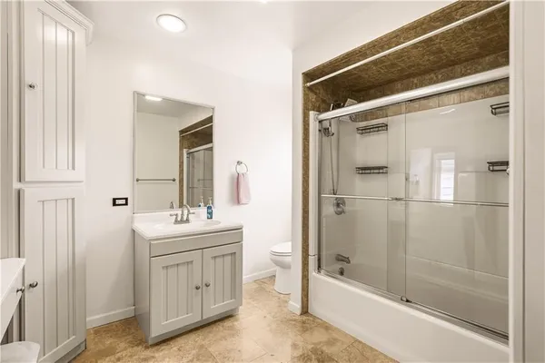 a bathroom with a bathtub a sink a vanity and a glass door shower
