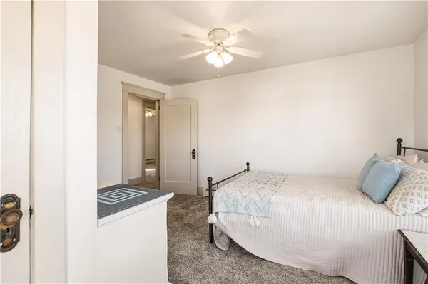 a bedroom with a bed and a ceiling fan