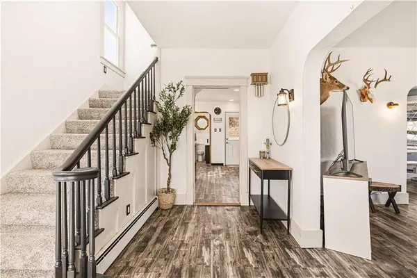 a view of a hallway with wooden floor and staircase