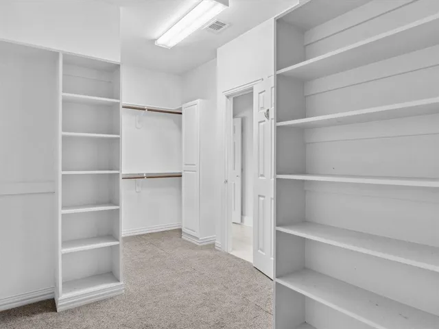 a view of walk in closet with empty racks